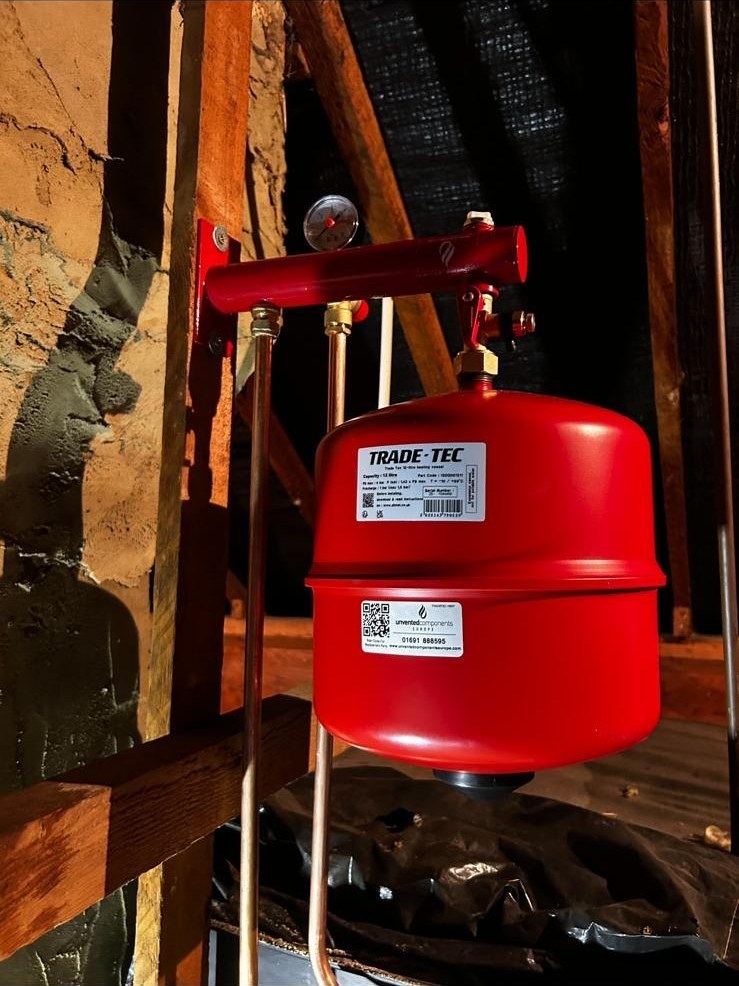 Red expansion vessel and copper pipework on a domestic heating system